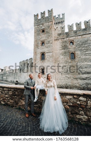 A happy young family walks through the old town of Sirmione in Italy.Stylish family in Italy on a walk