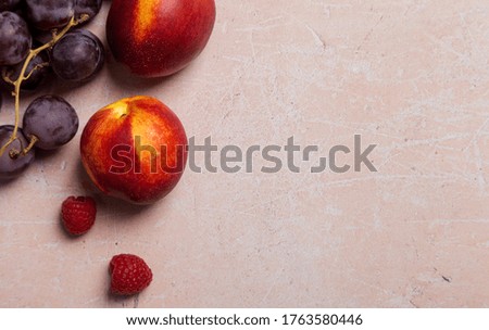 Copy space with nectarines and raspberry on pink concrete background