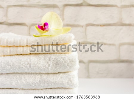 A stack of clean white Terry towels on a light background