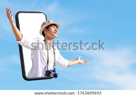 Young attractive asian man close eyes, wide open arm thru out phone. Happy asian male in new normal digital 360 virtual tour experiance, safe travel bubble, travel solution leisure technology concept. Royalty-Free Stock Photo #1763609693