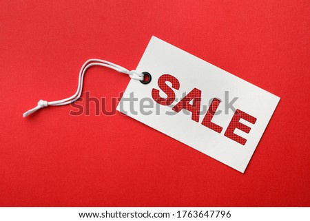 Tag with text SALE on red background, top view. Black Friday 
