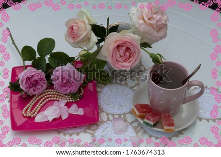 In the frame of roses is a cup of coffee with marmalade, a bouquet of pink roses, beads and rose petals.
