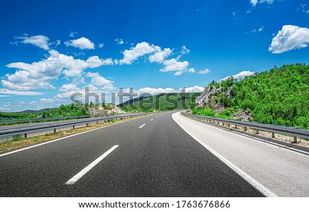 Mountain highway with blue sky and rocky mountains on a background