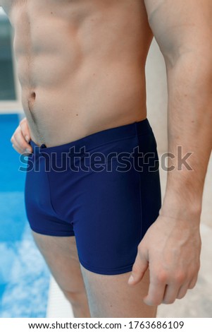 Sports man swims in the pool in a sports uniform.