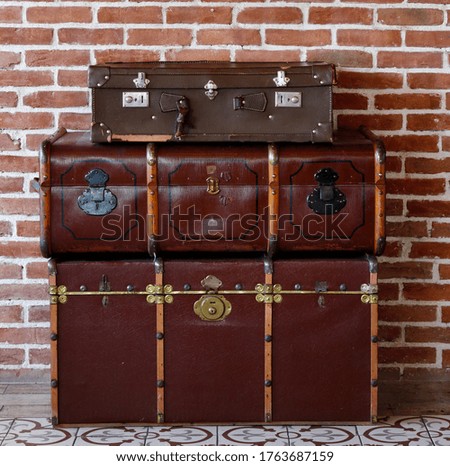 old suitcases in front of brick wall.