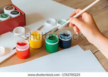child draws with a brush gouache