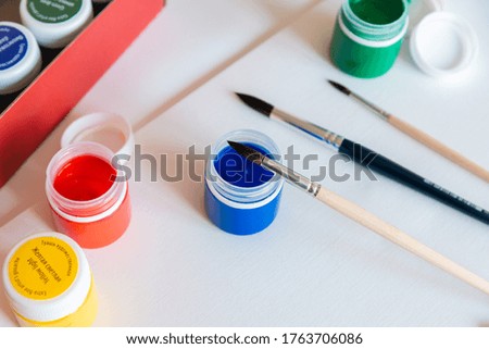 paint cans, brushes, and paper