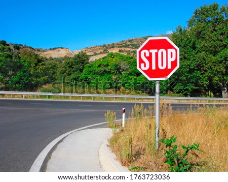 Stop sign in the countryside. Stop before leaving on the main road.