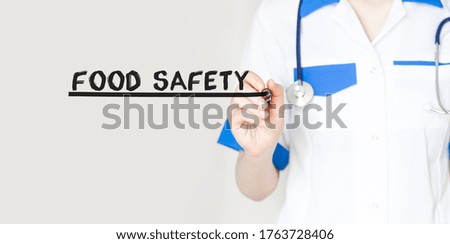 Doctor writing word Food Safety with marker, Medical concept