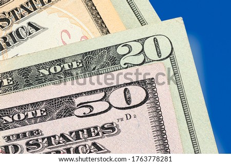 Many american dollar banknotes corner on the blue background. 