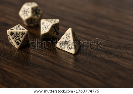 Decorative multi-purpose gaming dice. This set of dice of an interesting pattern carved out of each dice in the set. The dice have the highest number  on each one replaced with an arcane symbol. 