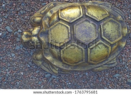 Bronze turtle on colored decorative crushed stone, image of a reptile for background.