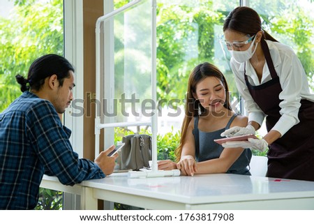 Staff using tablet for customer select menu meal in restaurant . New normal Waitress show and suggest food to customer in restaurant.
 Royalty-Free Stock Photo #1763817908
