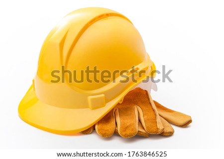 Middle class employment, labor day and industrial blue collar work concept with close up on a yellow hard hat and safety gloves isolated on white background with clipping path cutout