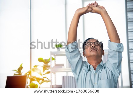 Senior adult Asian father is exercising to relax, relieve fatigue, stress at home from work for a long time. The era concept of living is popular today. Royalty-Free Stock Photo #1763856608