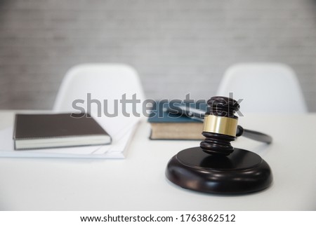 Wooden gavel and books on table in lawyer's office.