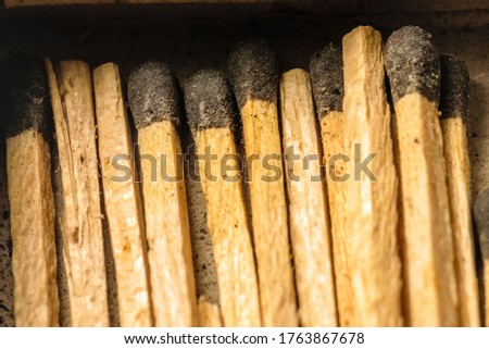 Match sticks are laying inside a match box in parallel