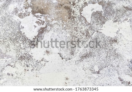 Close-up photo of the old cement wall outside the building with peeling paint and crack. The abstract old cement wall for decorative and design.