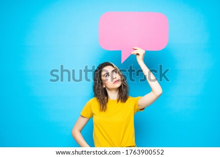 Young woman holding a speech bubble on a blue background