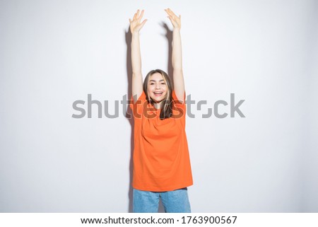 Portrait of a young woman with her hands up over white background