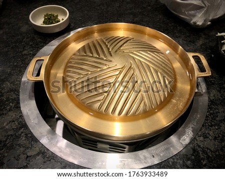 Grill pan, it is made of brass on the electric stove Royalty-Free Stock Photo #1763933489