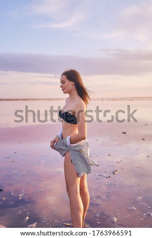 
girl in a swimsuit on the lake in pink