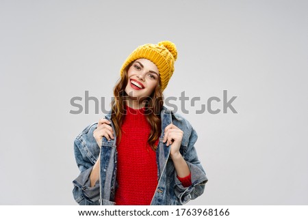 Denim jacket woman in a red sweater and makeup hat