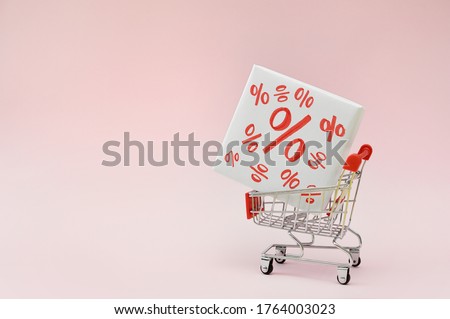 Image of empty shopping trolley or cart with box of discount percent sale black Friday products on pink background. Concept of sell or buy with place for your text Royalty-Free Stock Photo #1764003023