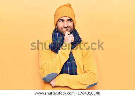 Young handsome bald man wearing winter clothes thinking concentrated about doubt with finger on chin and looking up wondering 