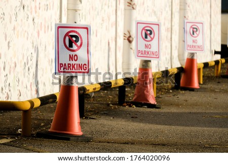 Selective focus picture of no parking sign at parking area during evening.