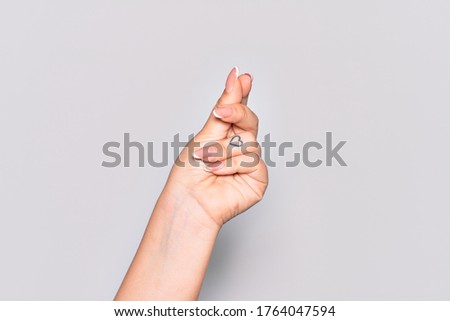 Hand of caucasian young woman holding blank space with thumb finger, business and advertising