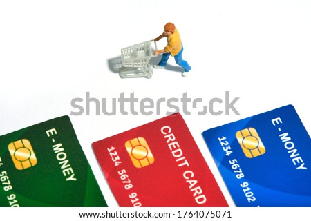 Contact-less payment. Women going shop and pay using electronic money (e-money). Miniature people figurines toys conceptual photography.