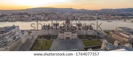 Panoramic aerial drone shot of Hungarian Parliament by Danube river in Kossuth Square in Budapest sunset in winter Royalty-Free Stock Photo #1764077357