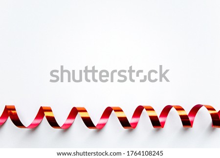 Decorative curled red ribbon isolated on white background with copy space. Concept of Christmas, valentines day, holiday