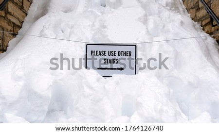 Panorama frame Snowed in stairway with sign that reads Please Use Other Stairs in winter