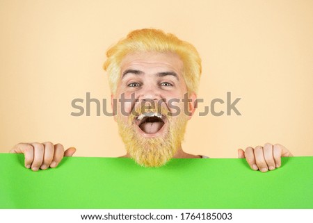 Close up portrait of handsome funny man showing green blank sign