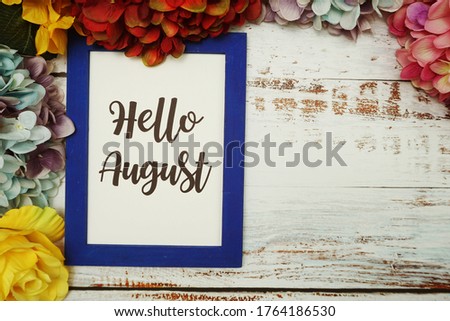 Hello August Card with colorful flowers border frame on wooden background