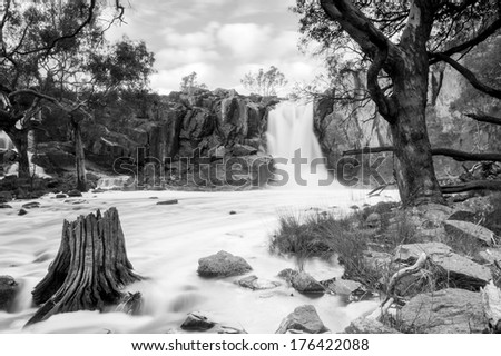 Beautiful Nigretta Falls waterfall in Western Victoria, Australia with high flow during winter time in time-lapse in stunning black and white
