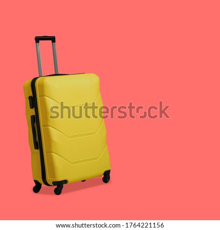 Plastic Yellow suitcase isolated on pink background. Suitcase with wheels and retractable telescopic handle. Travel concept. Template blank for social media banner.