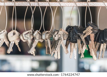 A conceptual image with hanging keys and one shining key. Many key chains for copy key on locksmith shop.