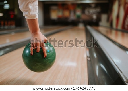 Close up of a  hand of young  caucasian girl while throwing a ball in a bowling club