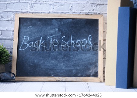 back to school concept with chalkboard and stack of book on table 
