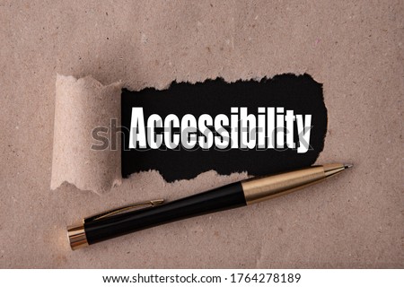 The word Accessibility is written under tear paper on a black background with a pen