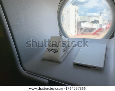 Red cabin pressure on aircraft door when parking on ground in normal situation. inside view from cabin.