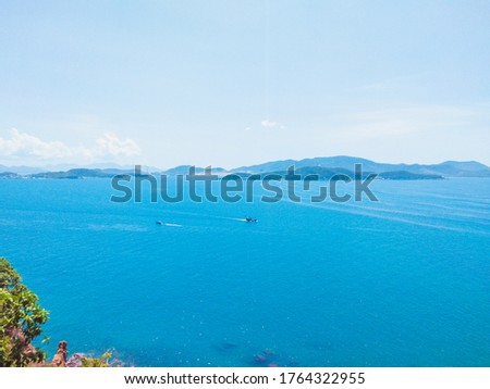 Deep blue ocean panorama with boat in a turquoise tropical sea under clear sky background. Tropical holiday paradise concept, the end of quarantine Covid 19 isolation - beginning of normal life again