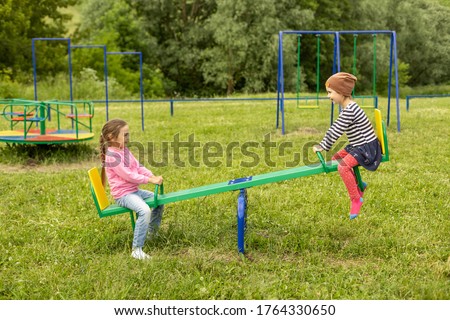 Two little girls have fun on a swing outdoors Royalty-Free Stock Photo #1764330650