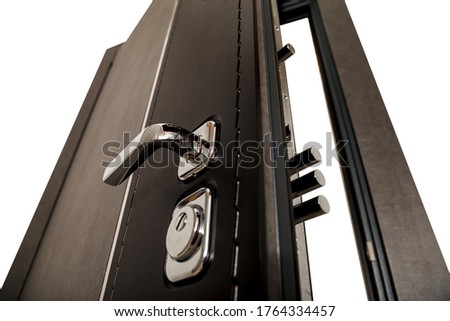 An open door with locks. Modern door with chrome metal handles and locks. Interior elements. Home security. Close-up of lock on armored door. Place for your creativity with space for text or logo Royalty-Free Stock Photo #1764334457