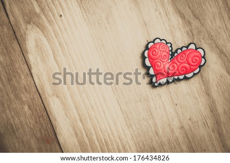 Pink ornate herat on wooden background, look from above