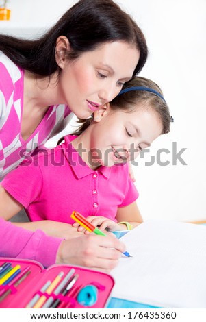 A mother helping her daughter with homework.