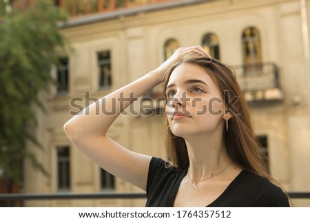 Portrait of a young girl. The concept of emotions. A girl enjoys a walk around the city after removal of quarantine measures.